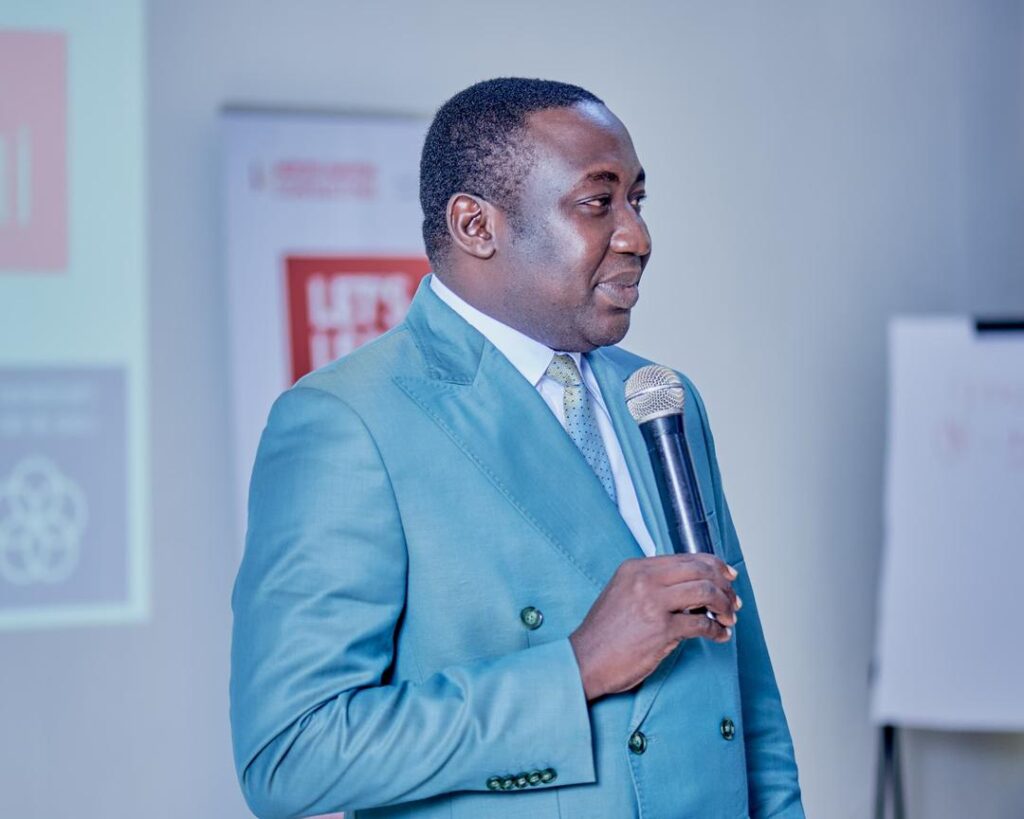 Abba Abdouraman wearing a blue suit and holding amic at the one youth one dream conference